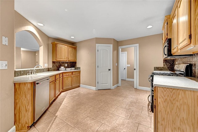 21 Sidlaw Hills Dr, Bella Vista, AR 72715 - kitchen with stainless steel appliances, tasteful backsplash, arched walkways, light countertops, and light tile patterned floors