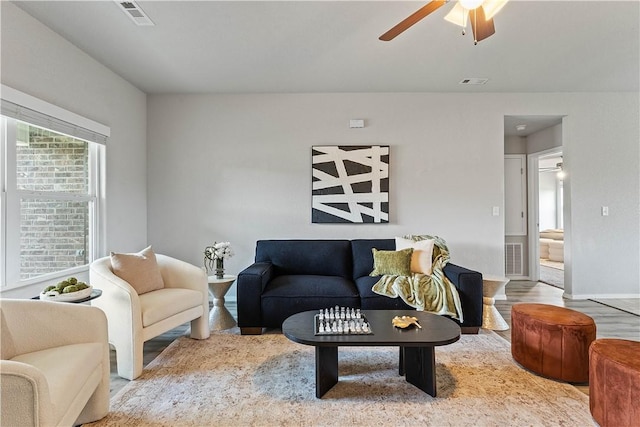 living area featuring ceiling fan, wood finished floors, and baseboards