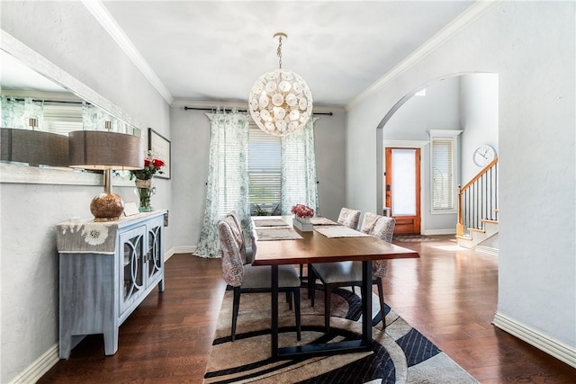 dining area featuring arched walkways, crown molding, wood finished floors, stairs, and baseboards