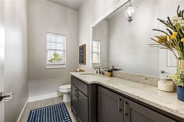 bathroom featuring vanity, toilet, and baseboards