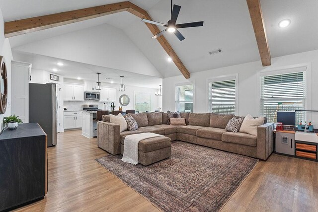 living area with ceiling fan, beamed ceiling, high vaulted ceiling, light wood-type flooring, and recessed lighting