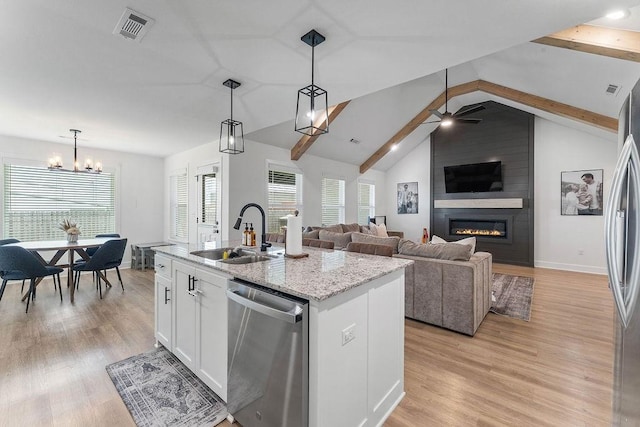 kitchen featuring appliances with stainless steel finishes, a sink, a large fireplace, white cabinets, and light wood-type flooring
