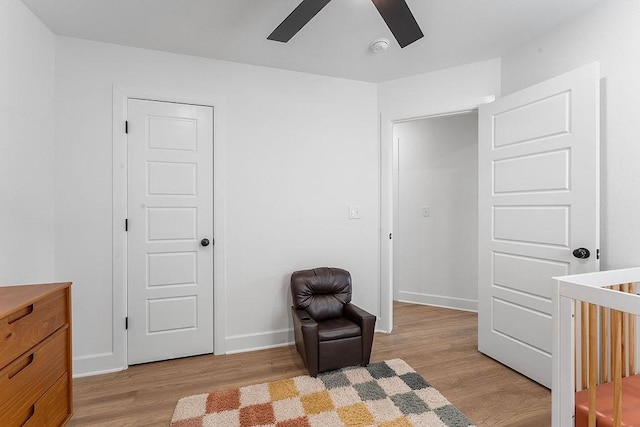 sitting room featuring a ceiling fan, light wood-type flooring, and baseboards