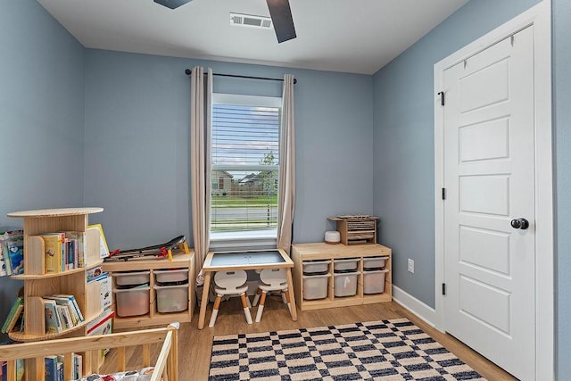 playroom featuring wood finished floors, baseboards, and a ceiling fan