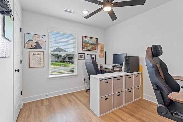 office featuring light wood-style flooring, a ceiling fan, and baseboards