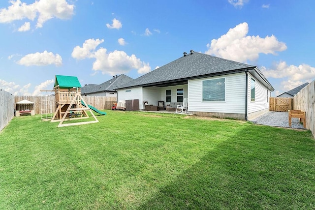 back of property with a playground, a patio area, and roof with shingles