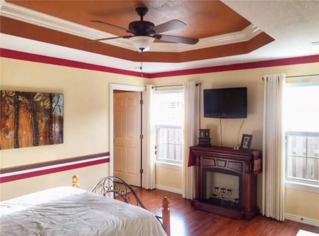 3801 SW Moline Ave, Bentonville, AR 72712 - bedroom with a raised ceiling, baseboards, wood finished floors, ornamental molding, and a ceiling fan