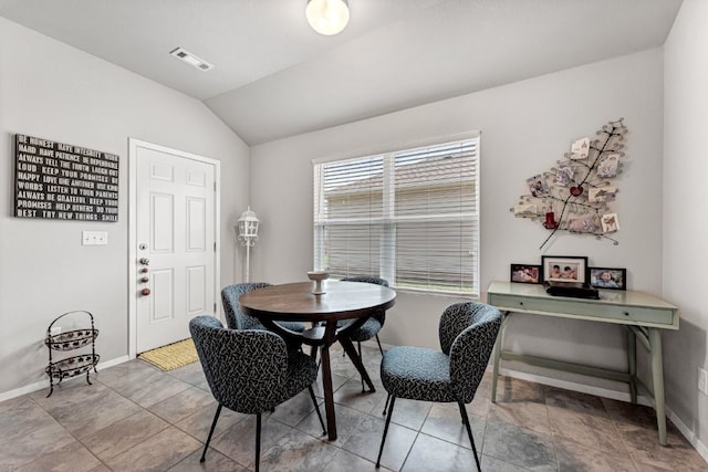 dining area featuring baseboards, vaulted ceiling, and tile patterned floors