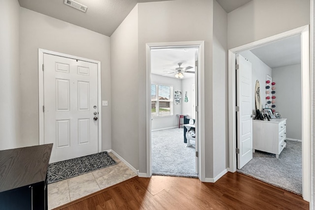 entrance foyer featuring wood finished floors, ceiling fan, baseboards, and carpet floors