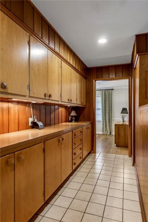 clothes washing area featuring wooden walls, light tile patterned floors, and recessed lighting