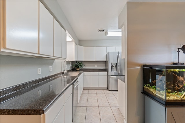 1207 SE E St, Bentonville, AR 72712 - kitchen with a sink, stainless steel appliances, white cabinetry, and light tile patterned floors