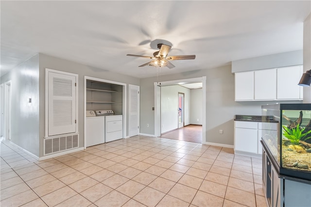 1207 SE E St, Bentonville, AR 72712 - kitchen featuring washer and dryer, a ceiling fan, white cabinets, light tile patterned flooring, and baseboards