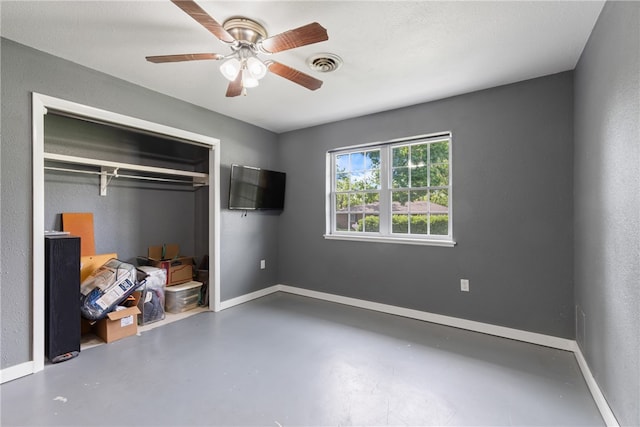 1207 SE E St, Bentonville, AR 72712 - unfurnished bedroom with concrete flooring, a closet, a ceiling fan, and baseboards