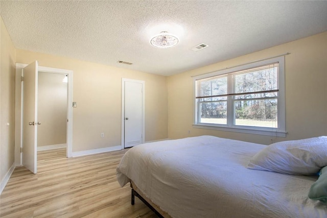 2193 Nevada 18 Rd, Prescott, AR 71857 - bedroom featuring light wood finished floors, a textured ceiling, and baseboards