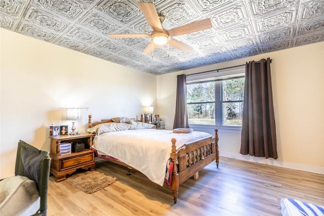 2193 Nevada 18 Rd, Prescott, AR 71857 - bedroom featuring an ornate ceiling, light wood finished floors, a ceiling fan, and baseboards