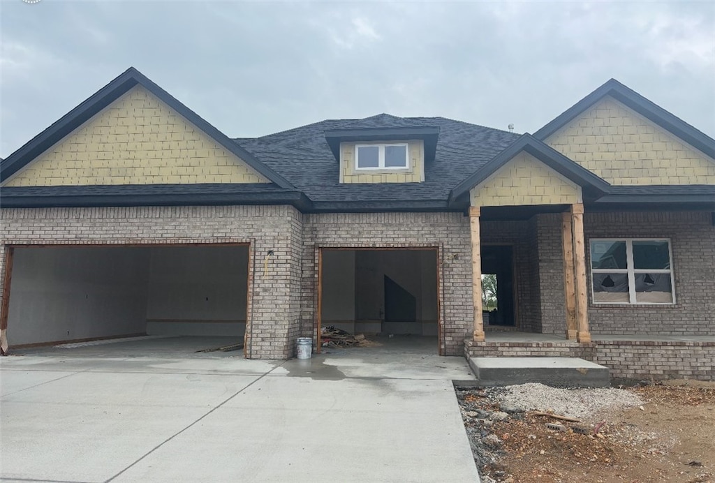 view of front of house with driveway, brick siding, and an attached garage