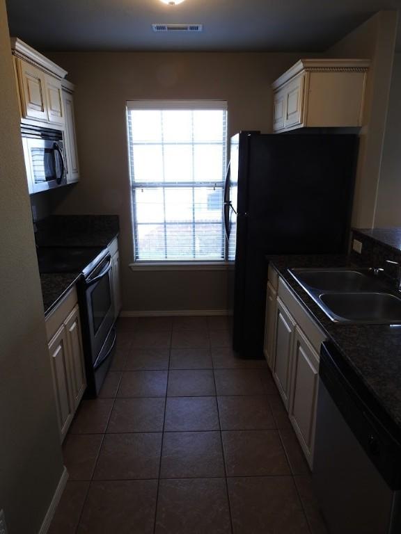 3804 Gibson Ave, Bentonville, AR 72712 - kitchen with stainless steel appliances, a sink, baseboards, and dark countertops