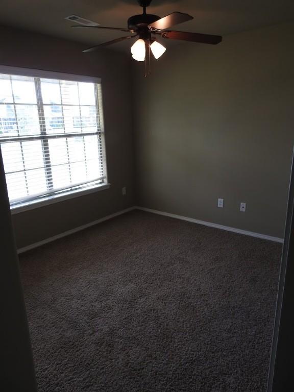 3804 Gibson Ave, Bentonville, AR 72712 - spare room featuring ceiling fan, baseboards, and dark carpet