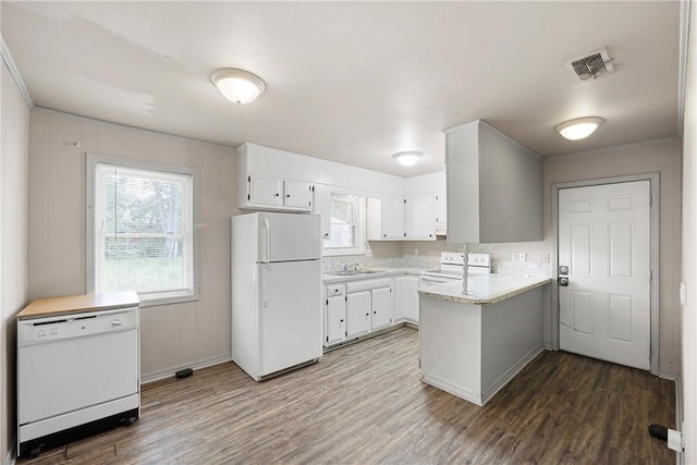 806 W 3rd St, Russellville, AR 72801 - kitchen with white appliances, a peninsula, light countertops, wood finished floors, and a sink