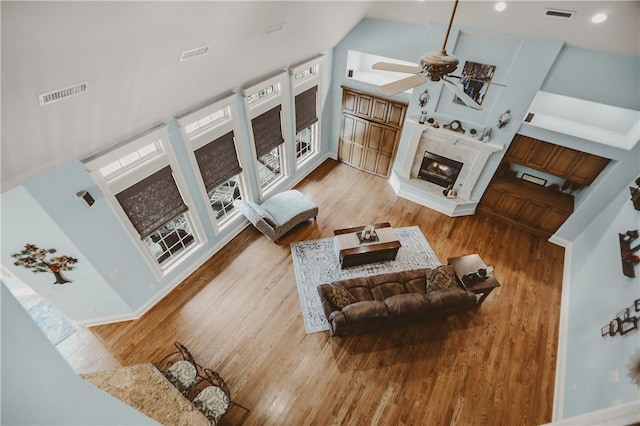 11136 W Stonebriar Dr, Bentonville, AR 72712 - living area featuring a ceiling fan, wood finished floors, a premium fireplace, baseboards, and high vaulted ceiling