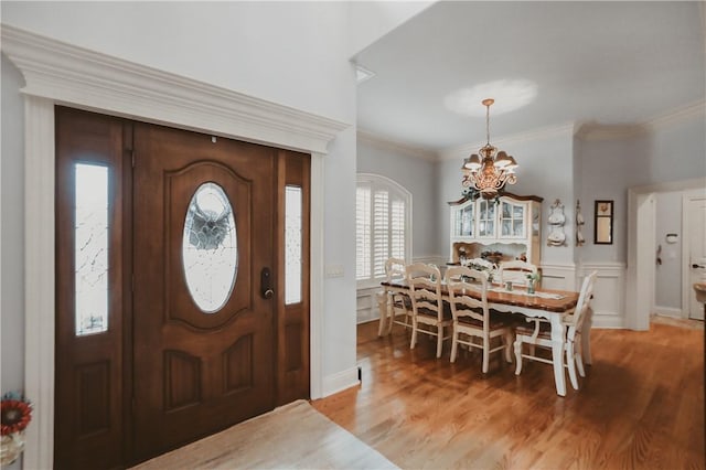 11136 W Stonebriar Dr, Bentonville, AR 72712 - entrance foyer featuring a chandelier, light wood-style floors, a wainscoted wall, and crown molding