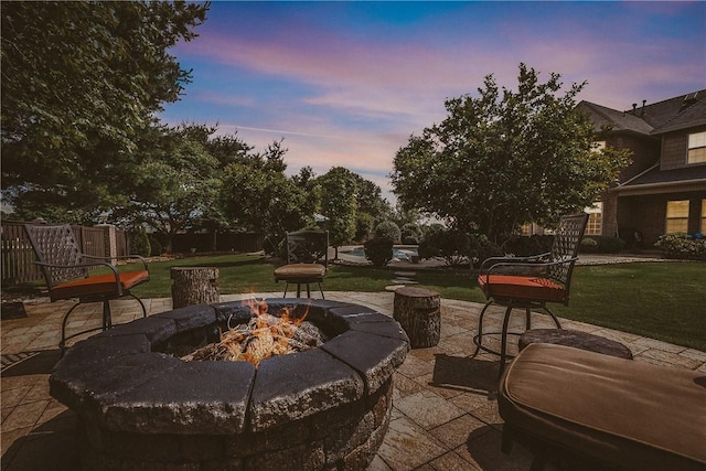 11136 W Stonebriar Dr, Bentonville, AR 72712 - patio terrace at dusk with an outdoor fire pit, a patio area, and a lawn