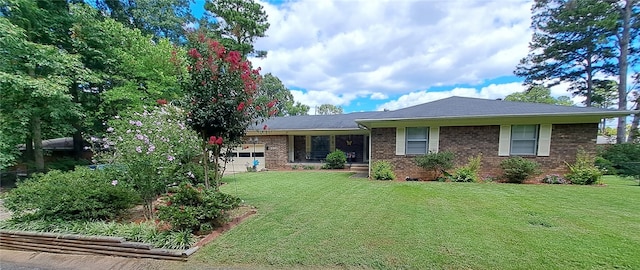ranch-style home featuring an attached garage, a front lawn, and brick siding