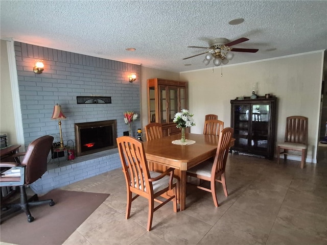 dining space featuring a textured ceiling, a ceiling fan, a fireplace, and ornamental molding