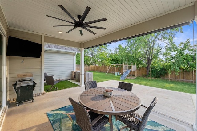 view of patio with outdoor dining area, ceiling fan, a playground, and grilling area