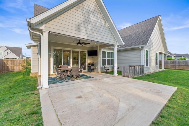 back of property with a ceiling fan, a patio area, a shingled roof, and outdoor dining space