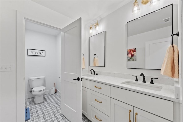 full bath with toilet, double vanity, baseboards, and tile patterned floors