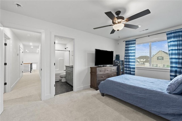 bedroom featuring carpet flooring, baseboards, ensuite bathroom, and a ceiling fan