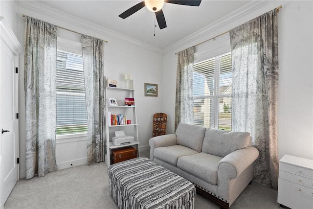 sitting room with a ceiling fan, healthy amount of natural light, ornamental molding, carpet flooring, and baseboards