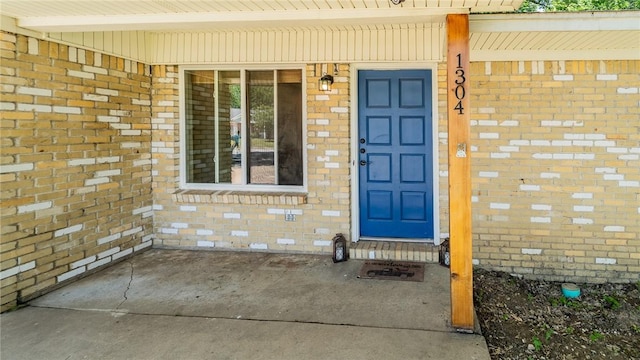 property entrance featuring brick siding