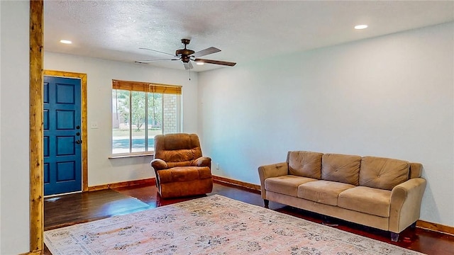 living area with baseboards, ceiling fan, wood finished floors, recessed lighting, and a textured ceiling