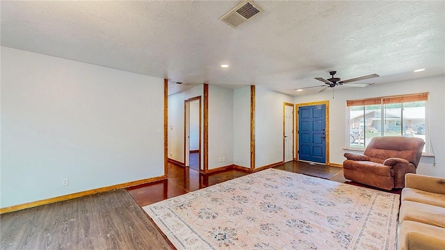 living area featuring dark wood-style flooring, baseboards, ceiling fan, a textured ceiling, and recessed lighting
