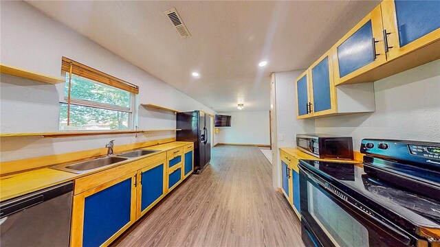 kitchen with black appliances, open shelves, a sink, light wood-style floors, and light countertops