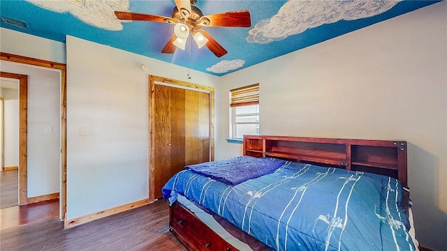 bedroom with wood finished floors, baseboards, a closet, and ceiling fan