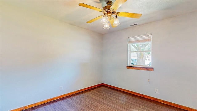 spare room with baseboards, wood finished floors, and ceiling fan