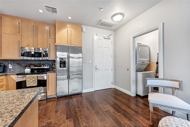 401 W Watson St Unit 408, Fayetteville, AR 72701 - kitchen with stainless steel appliances, stacked washer / dryer, light brown cabinets, dark wood-type flooring, and backsplash