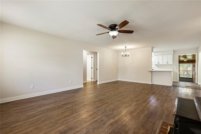 655 Bloomfield St, Gentry, AR 72734 - unfurnished living room featuring a ceiling fan, a chandelier, dark wood-style flooring, and baseboards