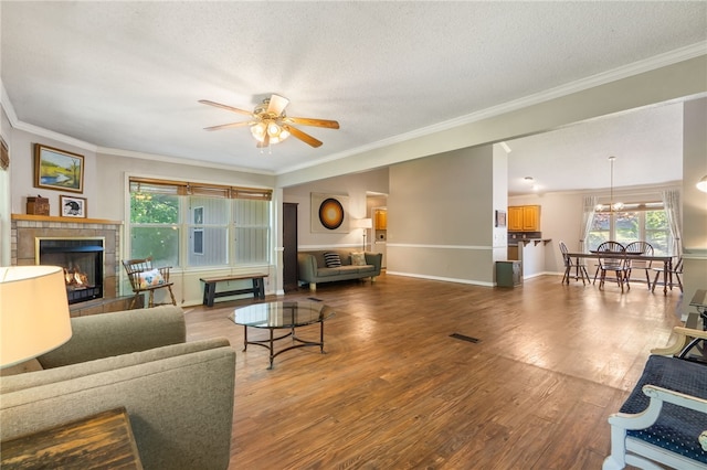 10 Forfar Cir, Bella Vista, AR 72715 - living area with a tile fireplace, a ceiling fan, wood finished floors, crown molding, and baseboards