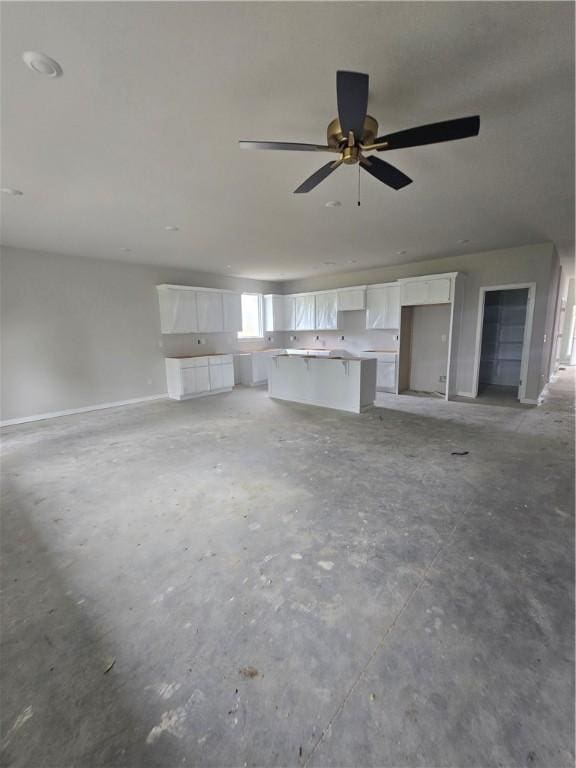 2308 Lexington St, Siloam Springs, AR 72761 - unfurnished living room featuring concrete floors and a ceiling fan