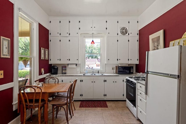 35 Kingshighway, Eureka Springs, AR 72632 - kitchen with freestanding refrigerator, gas range, black microwave, and white cabinetry