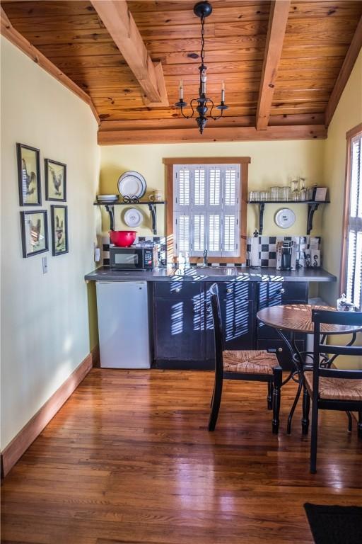 35 Kingshighway, Eureka Springs, AR 72632 - bar featuring wood ceiling with exposed beams, wood finished floors, black microwave, and baseboards