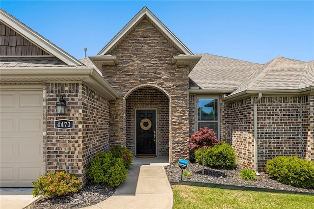 4471 W Oldham Dr, Fayetteville, AR 72704 - view of exterior entry with a shingled roof, brick siding, and an attached garage