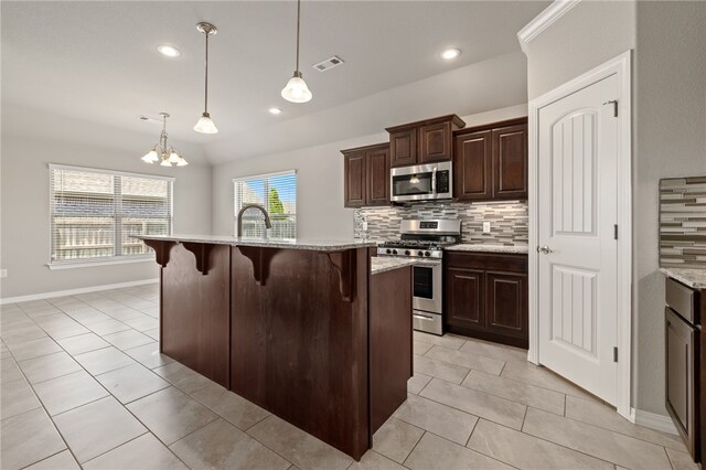 4471 W Oldham Dr, Fayetteville, AR 72704 - kitchen featuring stainless steel appliances, decorative backsplash, a breakfast bar, light tile patterned floors, and dark brown cabinetry