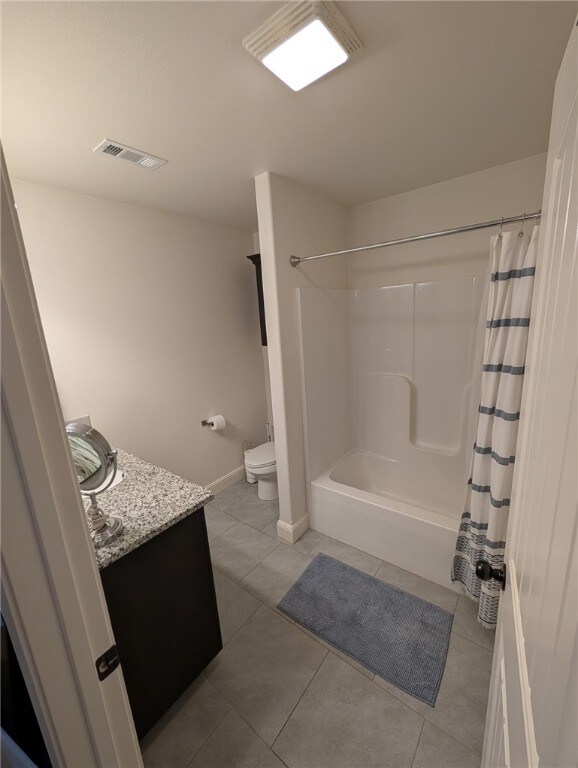 508 NW 62nd Ave, Bentonville, AR 72713 - bathroom featuring toilet, vanity, tile patterned flooring, baseboards, and shower / bath combo