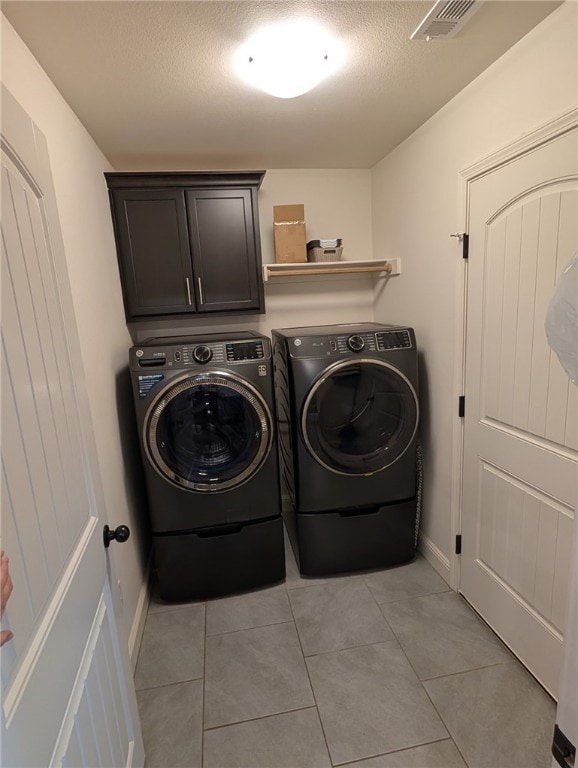 508 NW 62nd Ave, Bentonville, AR 72713 - laundry area featuring washing machine and clothes dryer, light tile patterned floors, a textured ceiling, baseboards, and cabinet space
