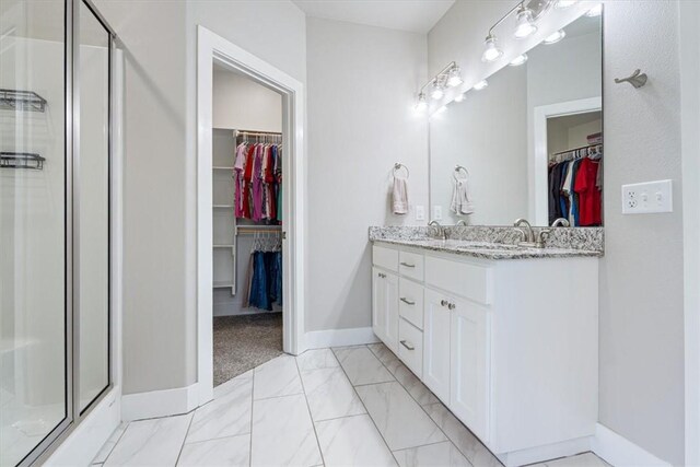 2204 N Kathryn Ln, Siloam Springs, AR 72761 - full bathroom with a stall shower, double vanity, marble finish flooring, baseboards, and a walk in closet